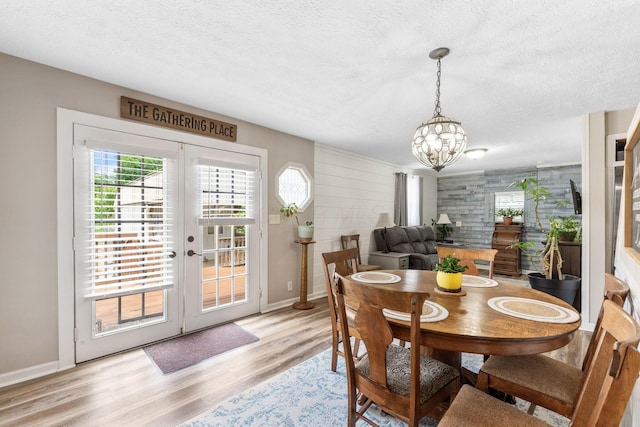 115 Maple Ave, Utica, OH 43080 - dining room featuring healthy amount of natural light, a chandelier, a textured ceiling, light wood finished floors, and french doors