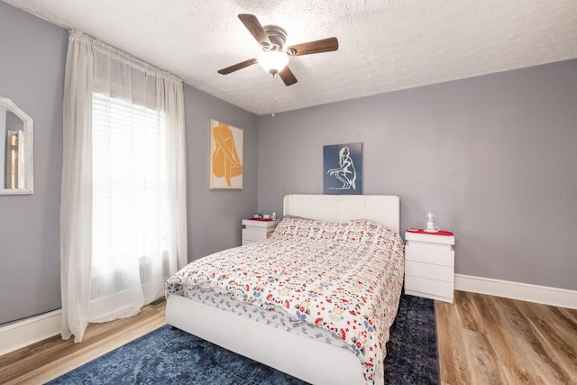 115 Maple Ave, Utica, OH 43080 - bedroom with wood finished floors, a textured ceiling, and a ceiling fan