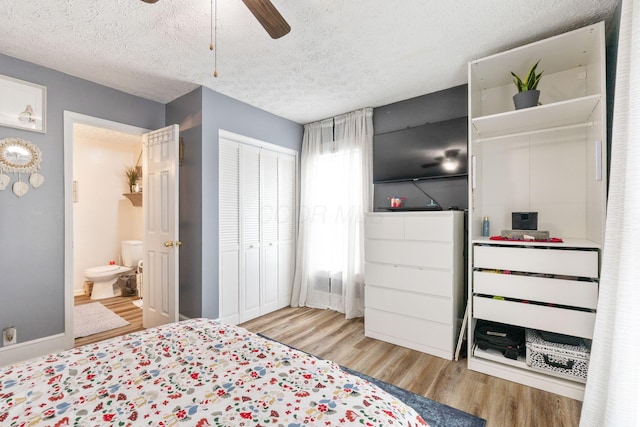 115 Maple Ave, Utica, OH 43080 - bedroom featuring wood finished floors, a closet, a textured ceiling, ensuite bathroom, and ceiling fan