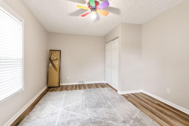 115 Maple Ave, Utica, OH 43080 - unfurnished bedroom with wood finished floors, a textured ceiling, a closet, and a ceiling fan
