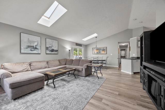 7838 Kiowa Way, Columbus, OH 43085 - living room featuring a skylight, vaulted ceiling, light wood finished floors, and a textured ceiling