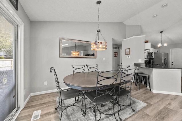 7838 Kiowa Way, Columbus, OH 43085 - dining area with a chandelier, vaulted ceiling, and light wood-type flooring