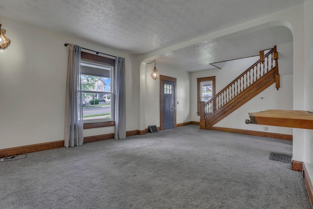 522 S Main St, New Lexington, OH 43764 - foyer featuring carpet, plenty of natural light, stairs, and a textured ceiling