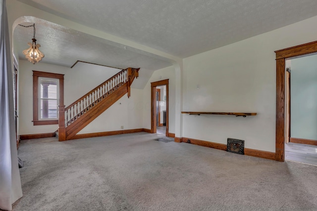 522 S Main St, New Lexington, OH 43764 - unfurnished living room with carpet flooring, stairway, and a textured ceiling