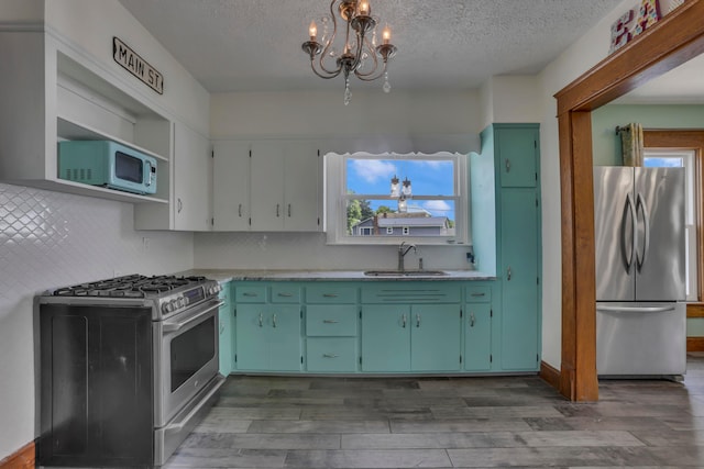 522 S Main St, New Lexington, OH 43764 - kitchen with appliances with stainless steel finishes, a chandelier, wood finished floors, a textured ceiling, and light countertops