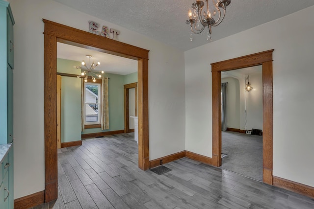 522 S Main St, New Lexington, OH 43764 - unfurnished room featuring a chandelier, wood tiled floors, and a textured ceiling
