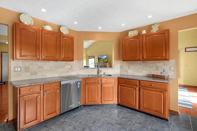 12961 Arabian Ct, Pickerington, OH 43147 - kitchen featuring stainless steel dishwasher, decorative backsplash, brown cabinetry, dark tile patterned flooring, and a textured ceiling