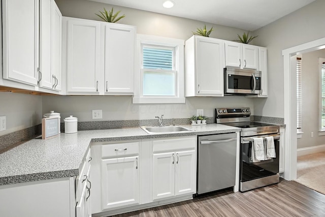 628 Reinhard Ave, Columbus, OH 43206 - kitchen with appliances with stainless steel finishes, white cabinets, light wood finished floors, and recessed lighting