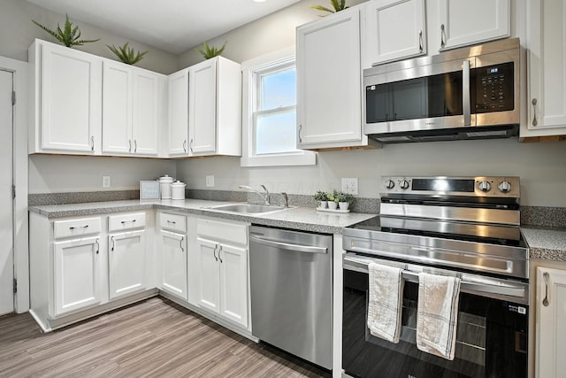 628 Reinhard Ave, Columbus, OH 43206 - kitchen with stainless steel appliances, white cabinetry, light countertops, and light wood-type flooring