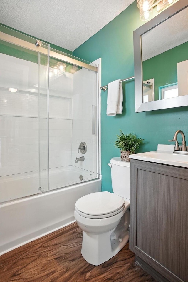 628 Reinhard Ave, Columbus, OH 43206 - full bathroom with vanity, bath / shower combo with glass door, wood finished floors, and a textured ceiling