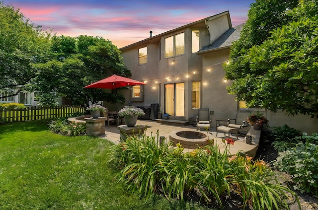 13191 Brandon Cir, Pickerington, OH 43147 - back of house at dusk featuring a fire pit, stucco siding, and a patio