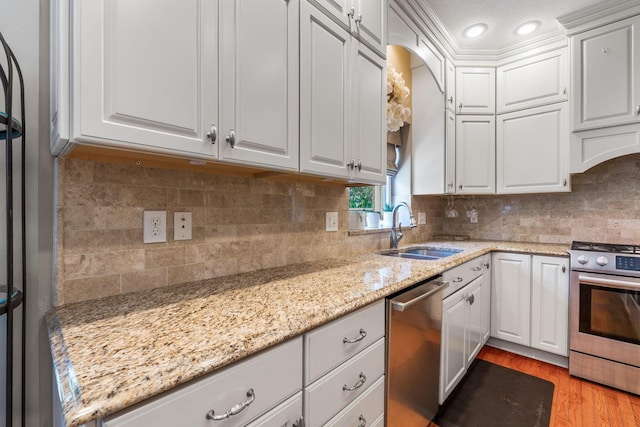 13191 Brandon Cir, Pickerington, OH 43147 - kitchen with appliances with stainless steel finishes, light wood finished floors, white cabinetry, light stone counters, and recessed lighting