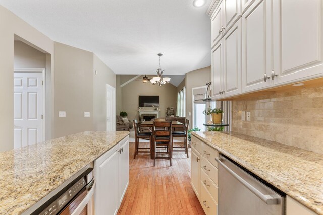 13191 Brandon Cir, Pickerington, OH 43147 - kitchen with stainless steel dishwasher, a chandelier, light wood finished floors, tasteful backsplash, and white cabinetry