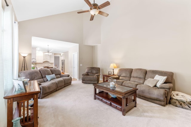 13191 Brandon Cir, Pickerington, OH 43147 - living room with high vaulted ceiling, light carpet, a ceiling fan, and a chandelier