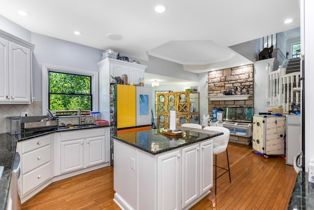 1800 Lynnbrook Ct, Orient, OH 43146 - kitchen with light wood-style flooring, white cabinets, a breakfast bar area, a center island, and decorative backsplash