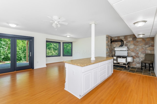 1800 Lynnbrook Ct, Orient, OH 43146 - kitchen with a wood stove, a ceiling fan, light wood-style floors, and white cabinets