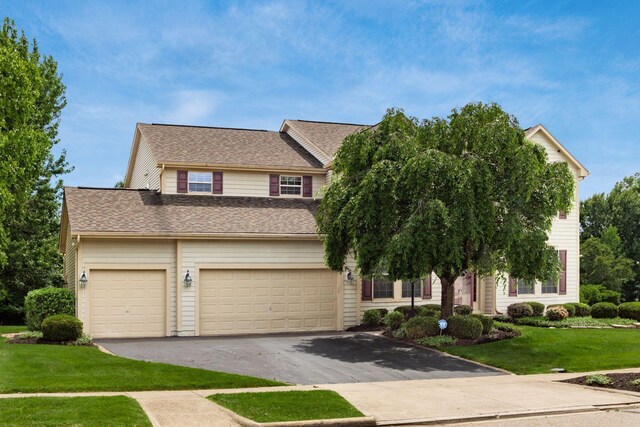 5630 Dorshire Dr, Galena, OH 43021 - view of front facade with asphalt driveway, a front yard, a garage, and a shingled roof