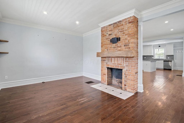 1382 S 5th St, Columbus, OH 43207 - unfurnished living room featuring dark wood-style flooring, a brick fireplace, crown molding, and recessed lighting