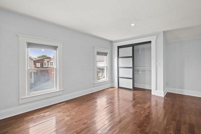 1382 S 5th St, Columbus, OH 43207 - unfurnished bedroom featuring multiple windows, hardwood / wood-style floors, and a closet
