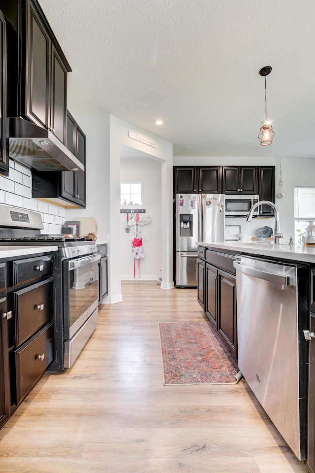 225 Messenger Way, Lewis Center, OH 43035 - kitchen featuring appliances with stainless steel finishes, range hood, light wood finished floors, decorative backsplash, and recessed lighting