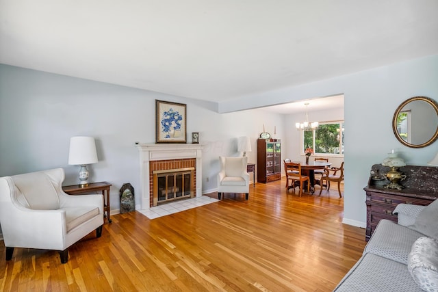 6750 Schreiner St E, Worthington, OH 43085 - living room featuring a chandelier, light wood finished floors, and a fireplace