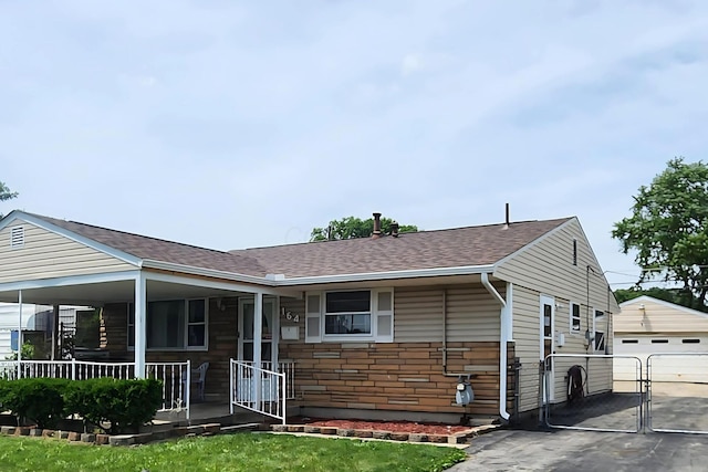 164 E Alcott Rd, Columbus, OH 43207 - view of front of home featuring covered porch, an outbuilding, a garage, and a shingled roof