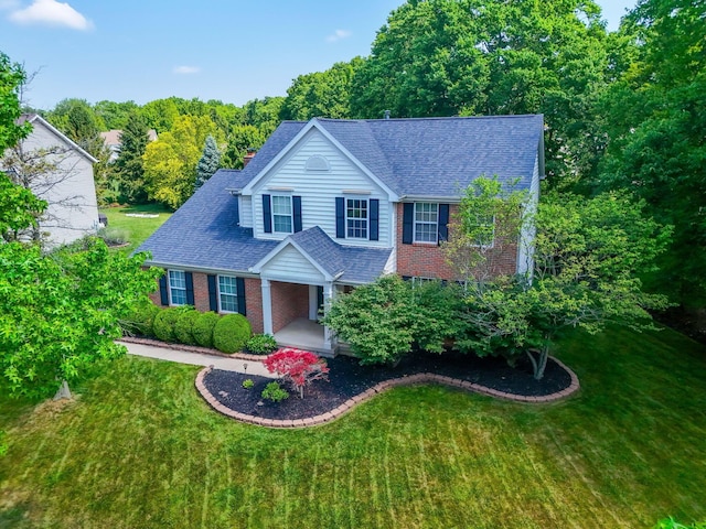 7672 Tullymore Dr, Dublin, OH 43016 - view of front of property featuring brick siding, a porch, a front lawn, and roof with shingles