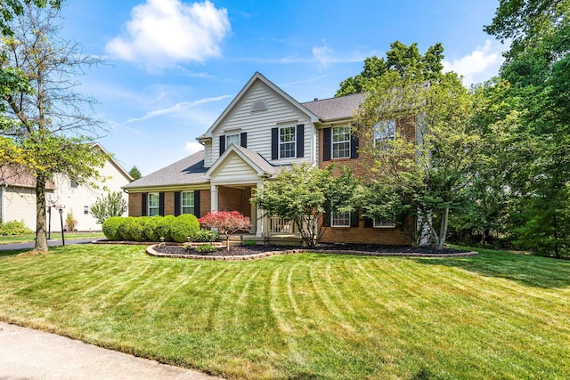 7672 Tullymore Dr, Dublin, OH 43016 - view of front facade with brick siding, a front lawn, a chimney, and covered porch