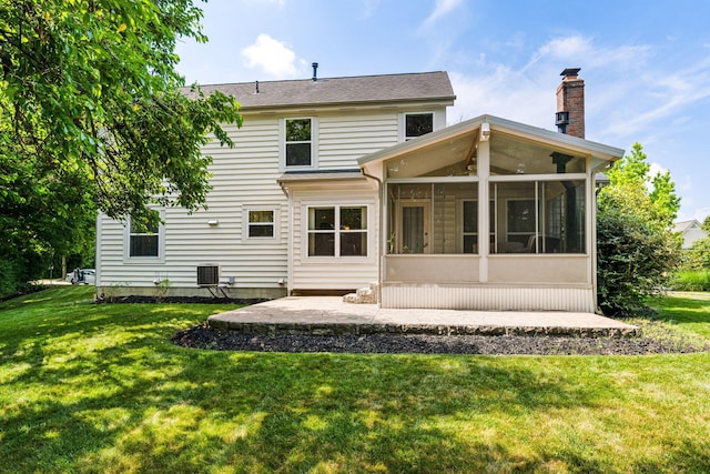 7672 Tullymore Dr, Dublin, OH 43016 - rear view of house featuring a sunroom, a patio area, a lawn, and a chimney