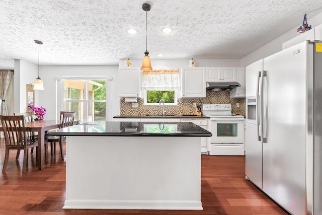 7672 Tullymore Dr, Dublin, OH 43016 - kitchen featuring white appliances, under cabinet range hood, dark countertops, white cabinets, and backsplash