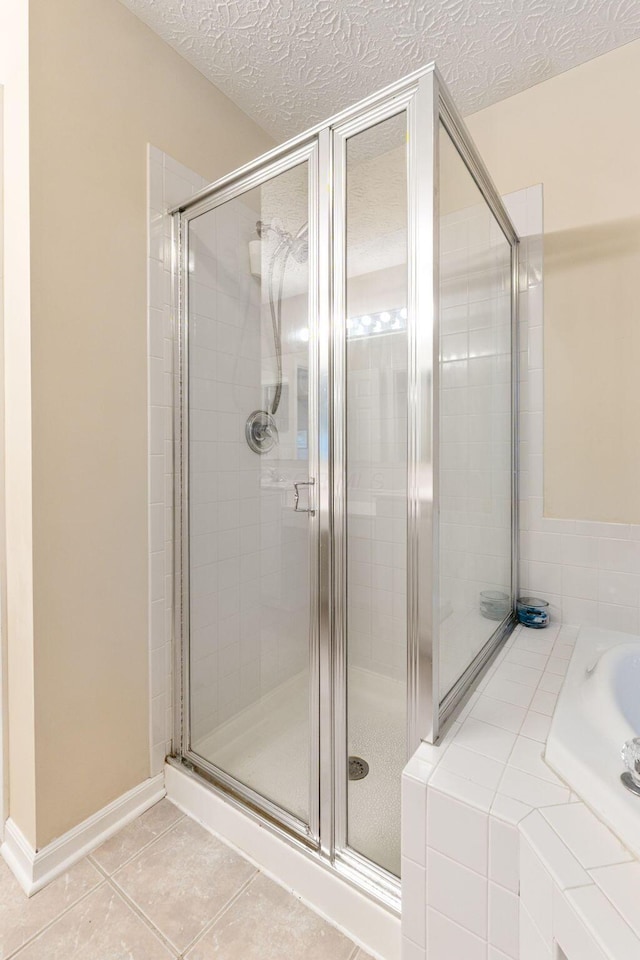 7672 Tullymore Dr, Dublin, OH 43016 - bathroom featuring a shower stall, a textured ceiling, tile patterned flooring, and tiled bath