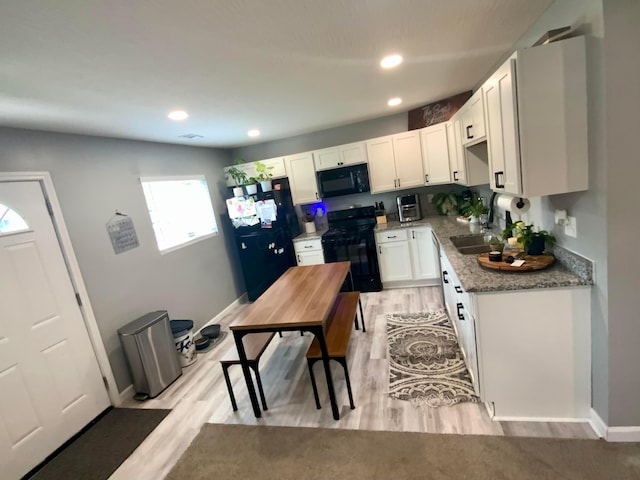 2901 Nuway Rd, Columbus, OH 43207 - kitchen featuring black appliances, light wood-style floors, white cabinets, light stone counters, and recessed lighting