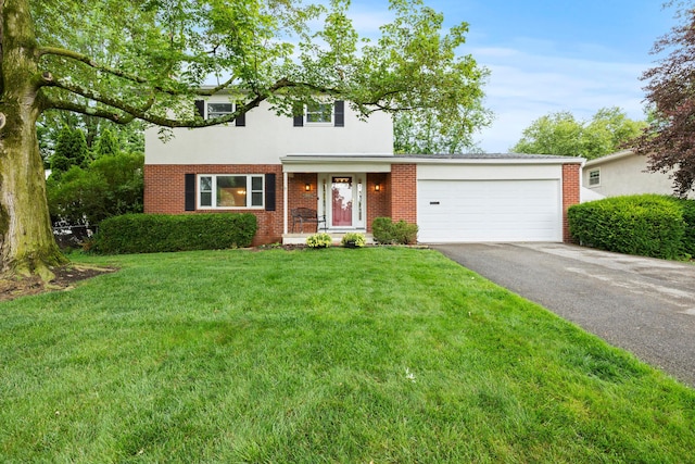 2681 Montcalm Rd, Columbus, OH 43221 - traditional-style home featuring driveway, an attached garage, a front yard, brick siding, and stucco siding