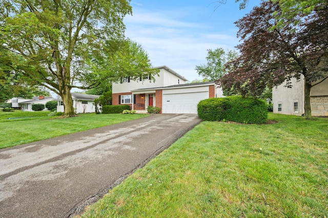 2681 Montcalm Rd, Columbus, OH 43221 - view of front of house featuring driveway, an attached garage, a front lawn, stucco siding, and brick siding