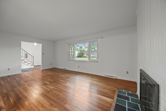 2681 Montcalm Rd, Columbus, OH 43221 - unfurnished living room with stairs, a tile fireplace, and wood finished floors