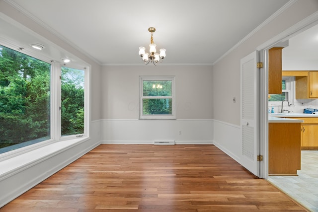 2681 Montcalm Rd, Columbus, OH 43221 - unfurnished dining area featuring light wood-style flooring, a chandelier, and crown molding