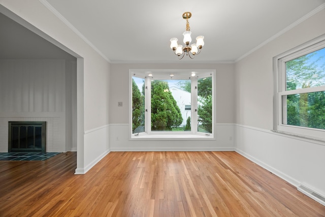 2681 Montcalm Rd, Columbus, OH 43221 - unfurnished dining area with plenty of natural light, wood finished floors, a chandelier, a wainscoted wall, and a glass covered fireplace