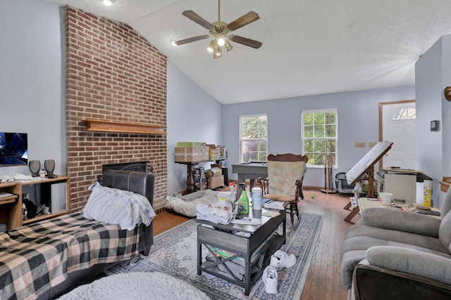 3490 Blendon Bend Way, Columbus, OH 43231 - living room with wood finished floors, a ceiling fan, vaulted ceiling, a brick fireplace, and a textured ceiling