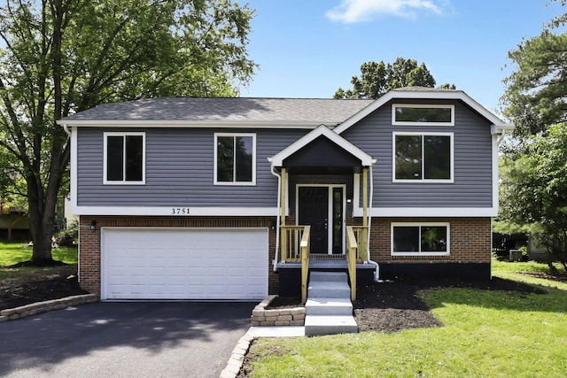 3751 Dolomite Dr, Columbus, OH 43230 - raised ranch featuring brick siding, an attached garage, driveway, a front lawn, and a shingled roof