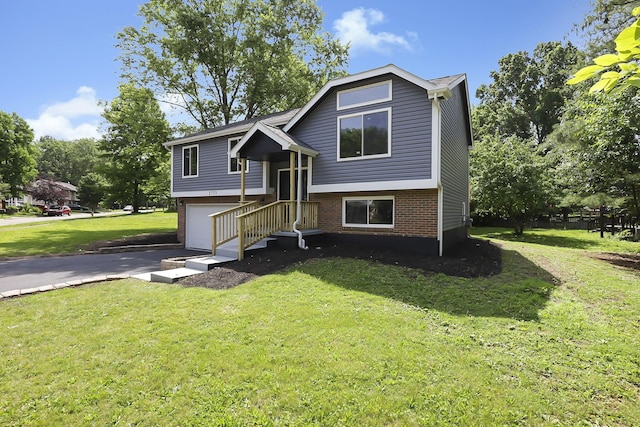 3751 Dolomite Dr, Columbus, OH 43230 - bi-level home featuring brick siding, a garage, a front lawn, and asphalt driveway