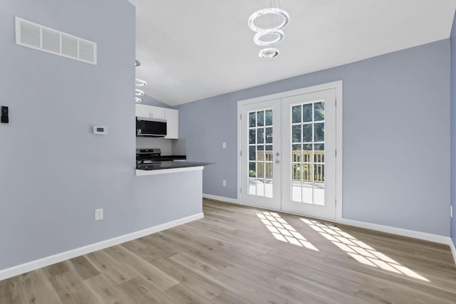 3751 Dolomite Dr, Columbus, OH 43230 - kitchen with appliances with stainless steel finishes, a chandelier, french doors, wood finished floors, and vaulted ceiling