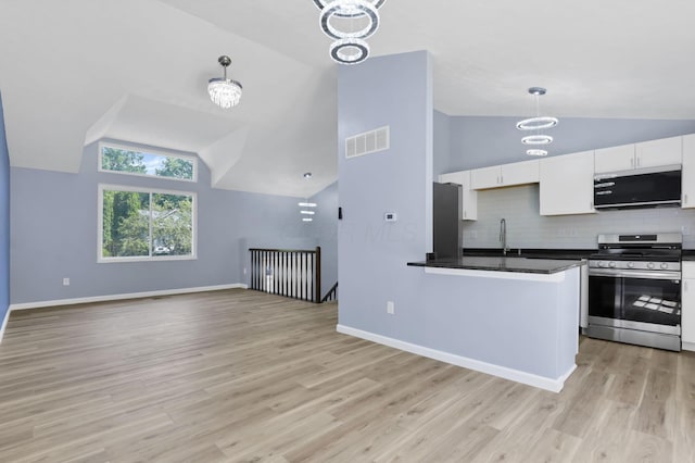 3751 Dolomite Dr, Columbus, OH 43230 - kitchen with appliances with stainless steel finishes, vaulted ceiling, dark countertops, white cabinetry, and decorative backsplash