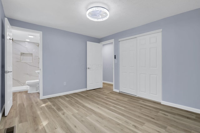 3751 Dolomite Dr, Columbus, OH 43230 - unfurnished bedroom with light wood finished floors, a closet, and ensuite bath