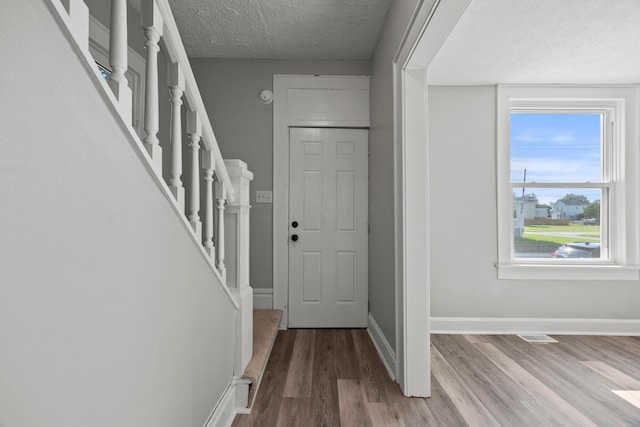 1765 S 8th St, Columbus, OH 43207 - entrance foyer featuring a textured ceiling, wood finished floors, and stairs
