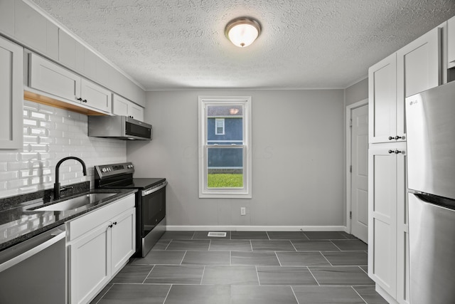 1765 S 8th St, Columbus, OH 43207 - kitchen with appliances with stainless steel finishes, decorative backsplash, white cabinetry, dark stone countertops, and crown molding