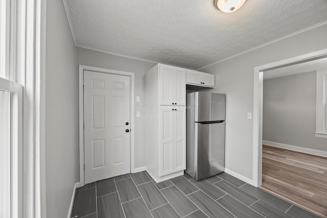 1765 S 8th St, Columbus, OH 43207 - kitchen with freestanding refrigerator, white cabinetry, ornamental molding, wood finish floors, and a textured ceiling