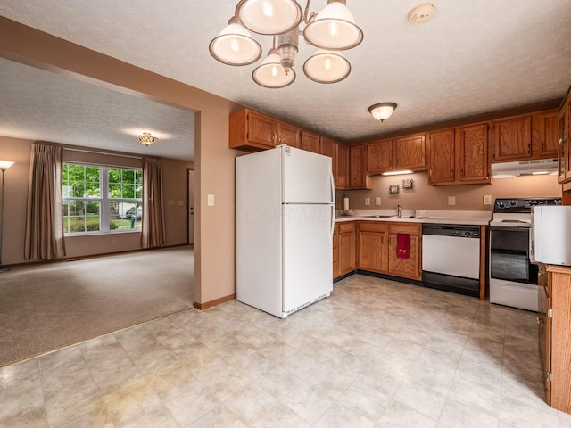 1225 El Toro Dr, Columbus, OH 43204 - kitchen with white appliances, under cabinet range hood, a textured ceiling, light countertops, and brown cabinetry