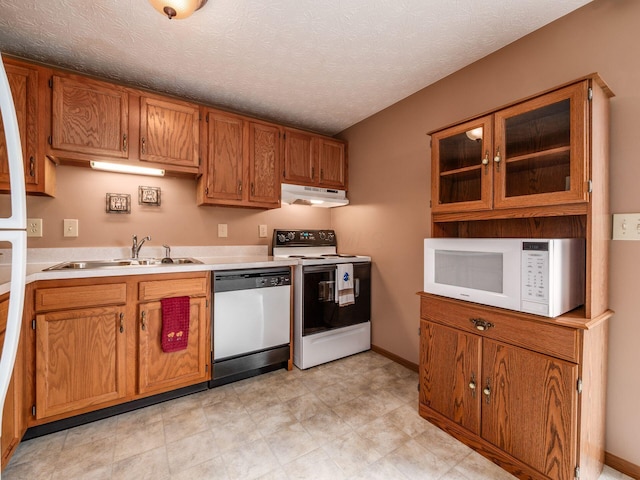 1225 El Toro Dr, Columbus, OH 43204 - kitchen featuring white appliances, under cabinet range hood, light countertops, and brown cabinetry