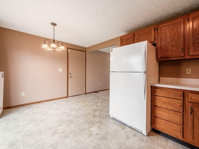 1225 El Toro Dr, Columbus, OH 43204 - kitchen with freestanding refrigerator, brown cabinets, light countertops, decorative light fixtures, and light floors