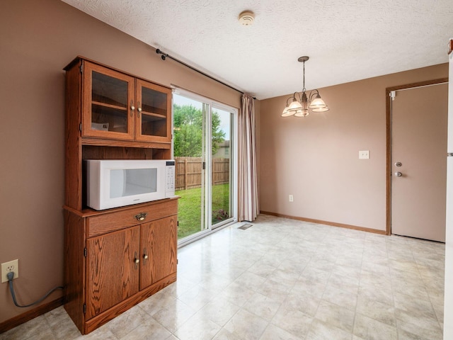 1225 El Toro Dr, Columbus, OH 43204 - unfurnished dining area with a chandelier and a textured ceiling